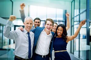 Group of professionals raising their hands excitedly. 