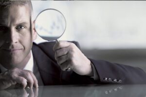 Professional holding up a magnifying glass